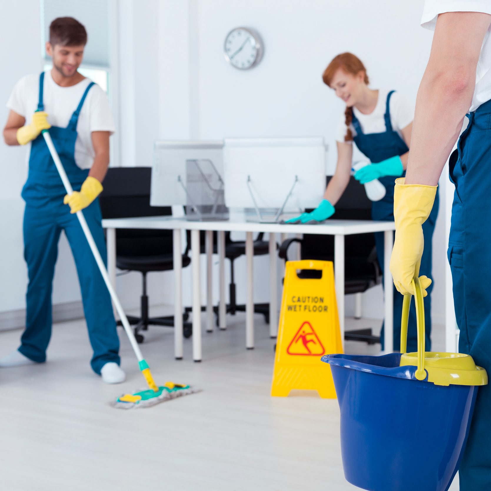 Team of cleaners cleaning an office using cleaning tools