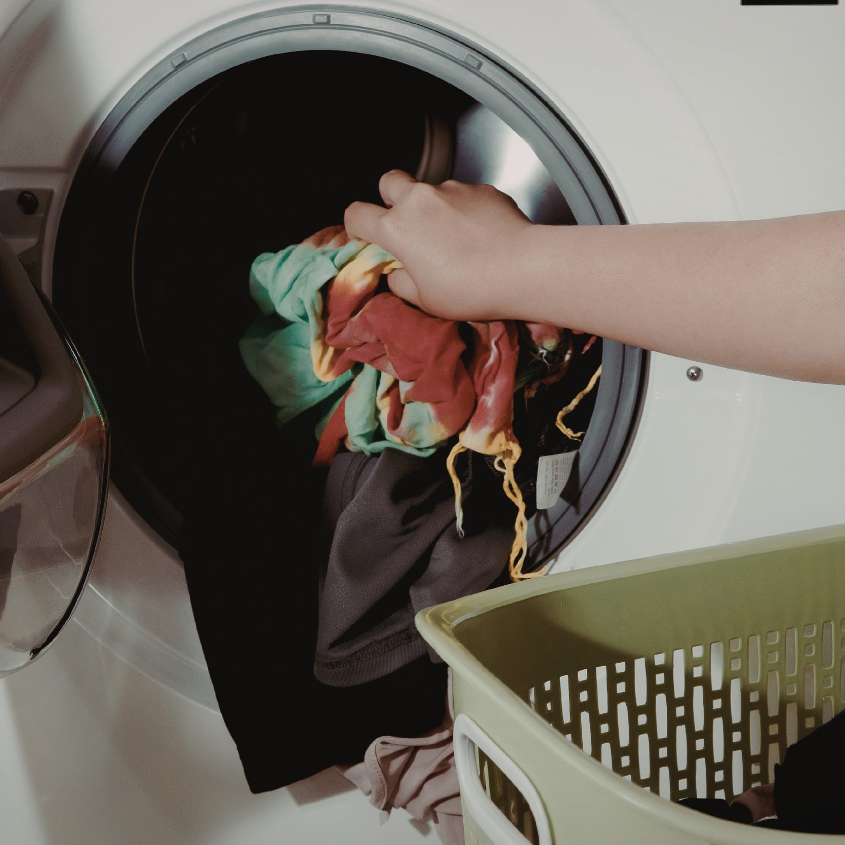 Hand putting a laundry in the laundry machine